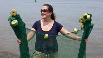 Meghan Marrero holding a fishing sampling net in the water
